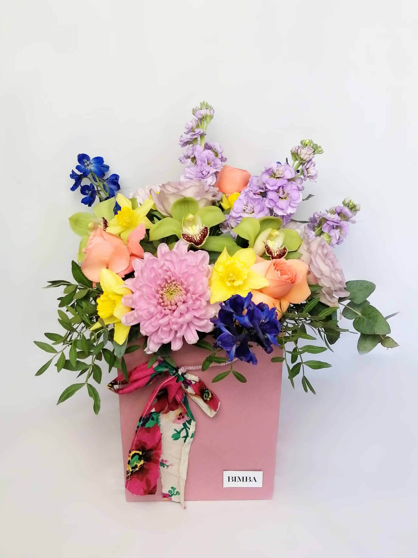 Candy, Lovely and romantic but at the same time very vibrant and colourful flower bouquet featuring luxury orchids, lovely roses, sweet scented stock, strawberry chrysanthemums, spring daffodils (only in early spring), blue bell and scented eucalyptus.. By Bimba Floral Studio.