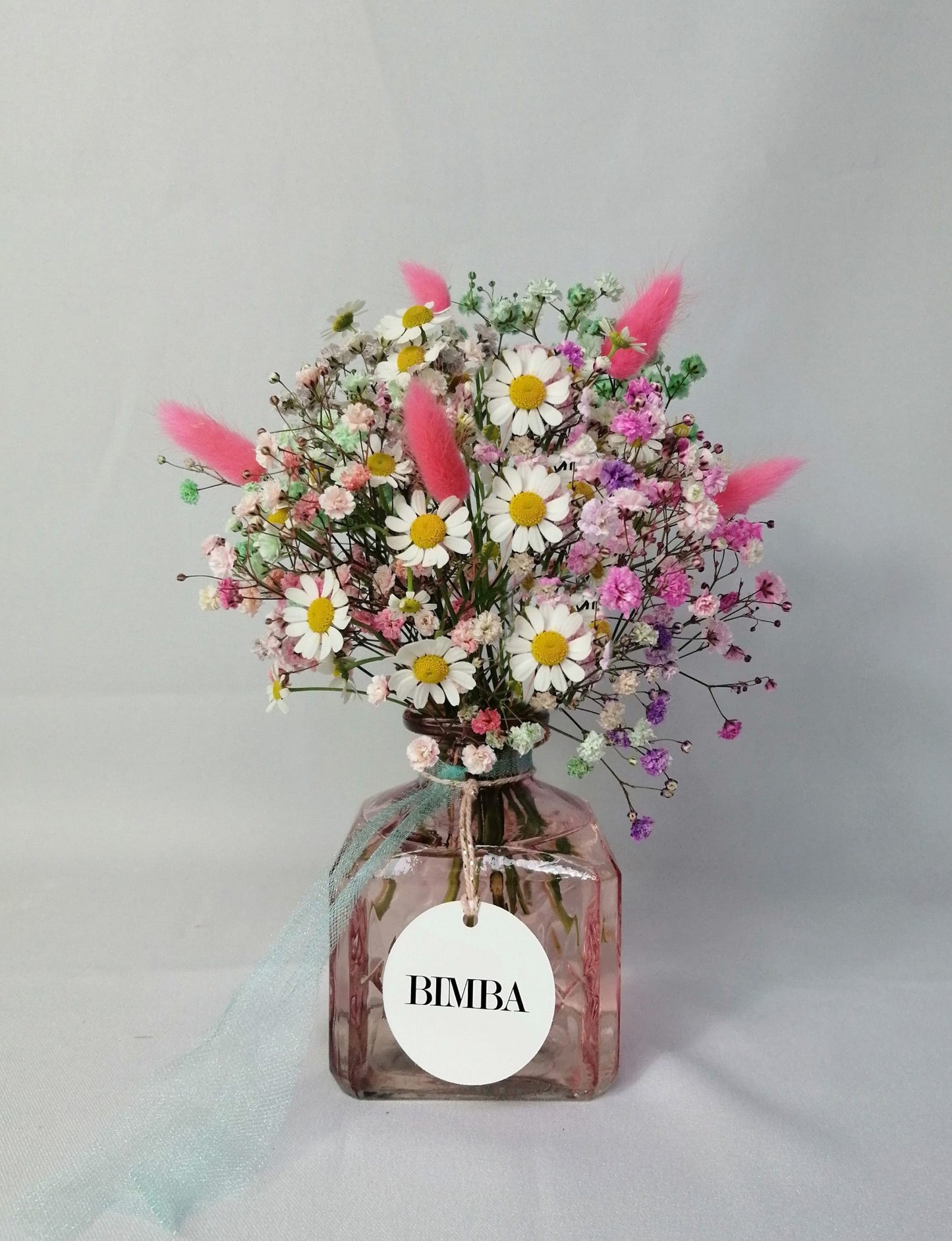 Happiness in a bouquet!! :) Perfect to add a pop of colour like a little rainbow to any place. Mini floral arrangement featuring rainbow gypsophila, chamomile flower and floppy bunny tails in a lovely vintage style glass vase, ready to enjoy. By Bimba Floral Studio.