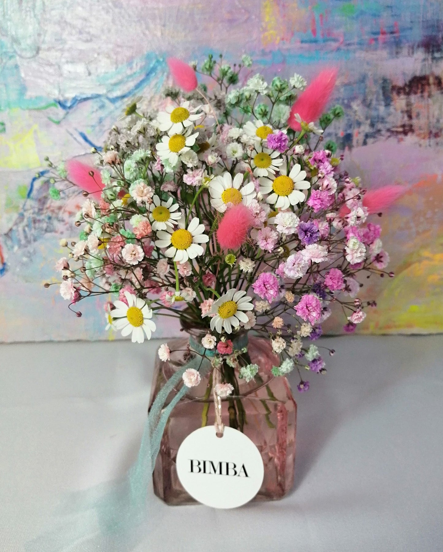 Happiness in a bouquet!! :) Perfect to add a pop of colour like a little rainbow to any place. Mini floral arrangement featuring rainbow gypsophila, chamomile flower and floppy bunny tails in a lovely vintage style glass vase, ready to enjoy. By Bimba Floral Studio.