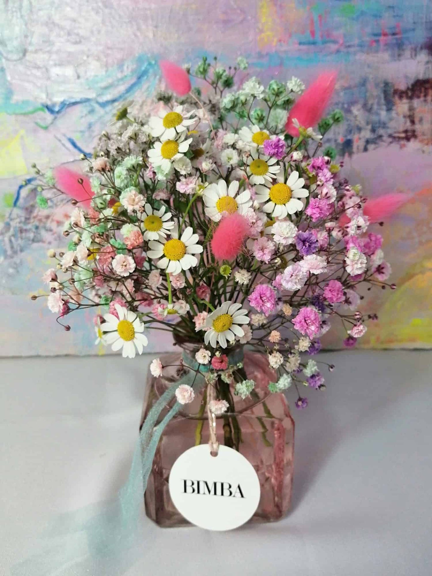 Happiness in a bouquet!! :) Perfect to add a pop of colour like a little rainbow to any place. Mini floral arrangement featuring rainbow gypsophila, chamomile flower and floppy bunny tails in a lovely vintage style glass vase, ready to enjoy. By Bimba Floral Studio.