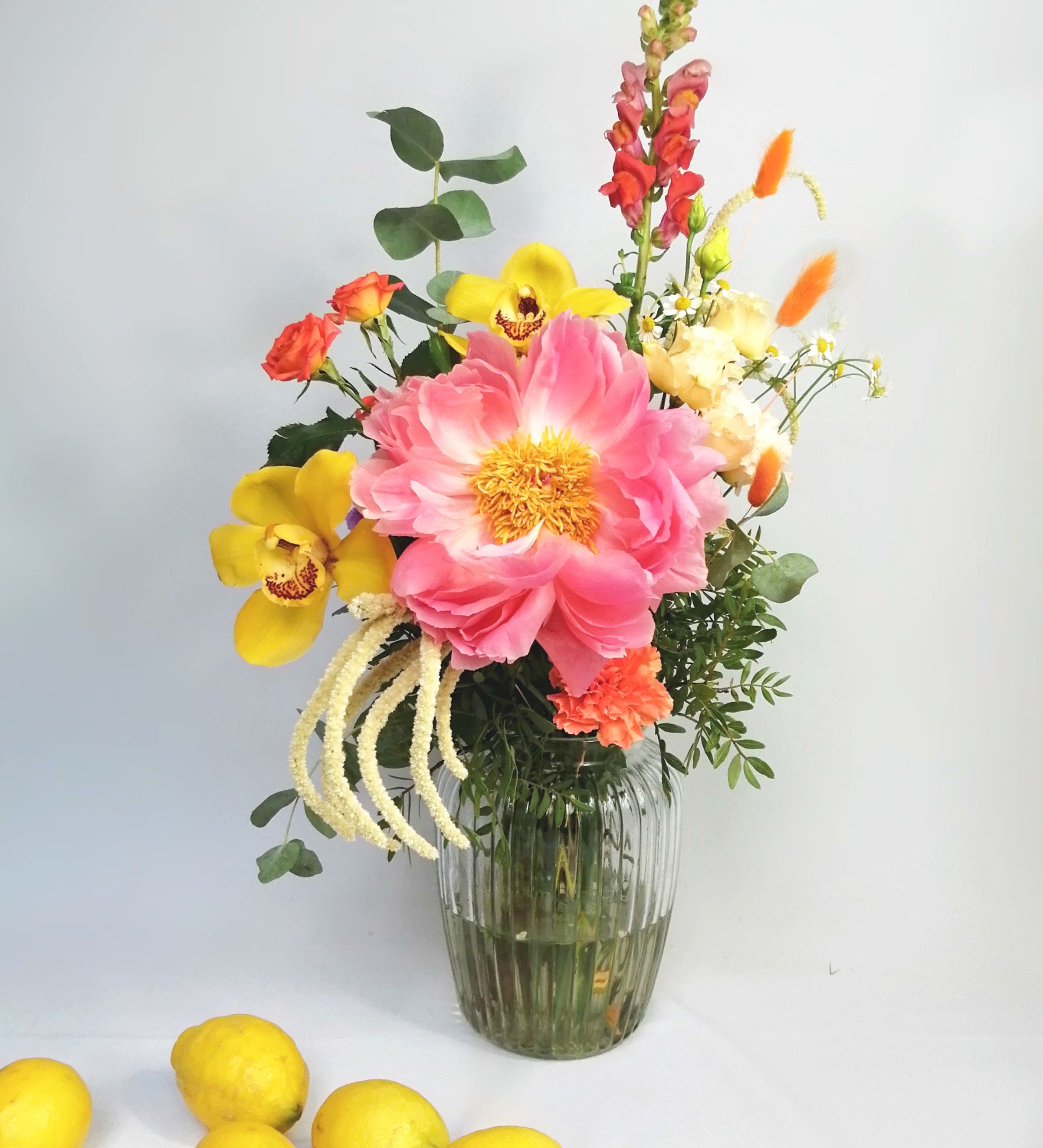 Lovely and happy! Summery flower arrangement in orange, coral and cream tones, featuring, double lisi, Amaranthus, orange roses, dancer Caribbean orchids, snapdragon, bunny tails and our star of the season Peony 'coral charm' abundant, nostalgic, large, elegant glossy coral-cream coloured, semi-double flowers with a slight fragrance as they mature. Just beautiful!! This flower bouquet is available for same day delivery and next day delivery at our floral studio at Highgate ( North London Flowers ).