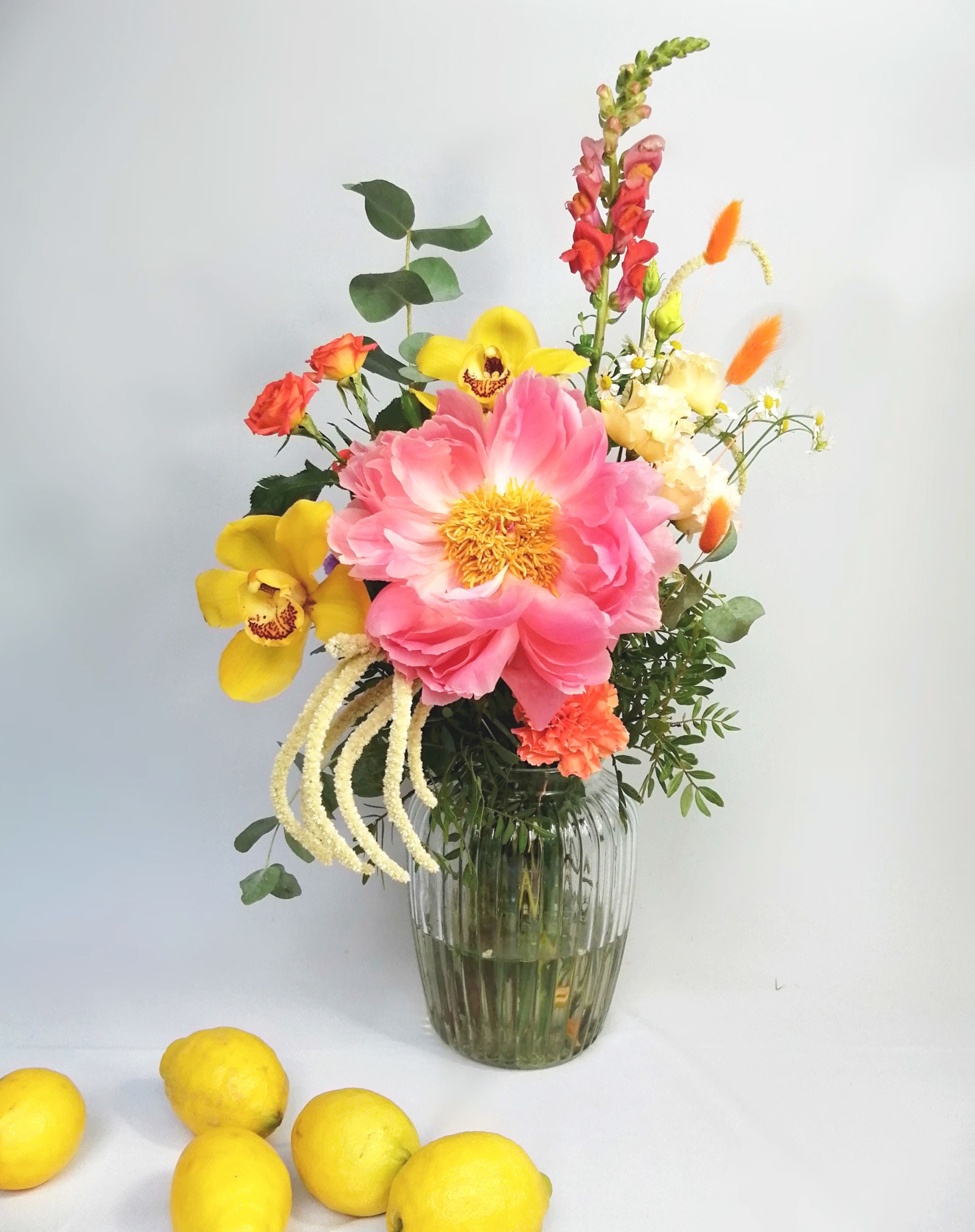 Lovely and happy! Summery flower arrangement in orange, coral and cream tones, featuring, double lisi, Amaranthus, orange roses, dancer Caribbean orchids, snapdragon, bunny tails and our star of the season Peony 'coral charm' abundant, nostalgic, large, elegant glossy coral-cream coloured, semi-double flowers with a slight fragrance as they mature. Just beautiful!! This flower bouquet is available for same day delivery and next day delivery at our floral studio at Highgate ( North London Flowers ).