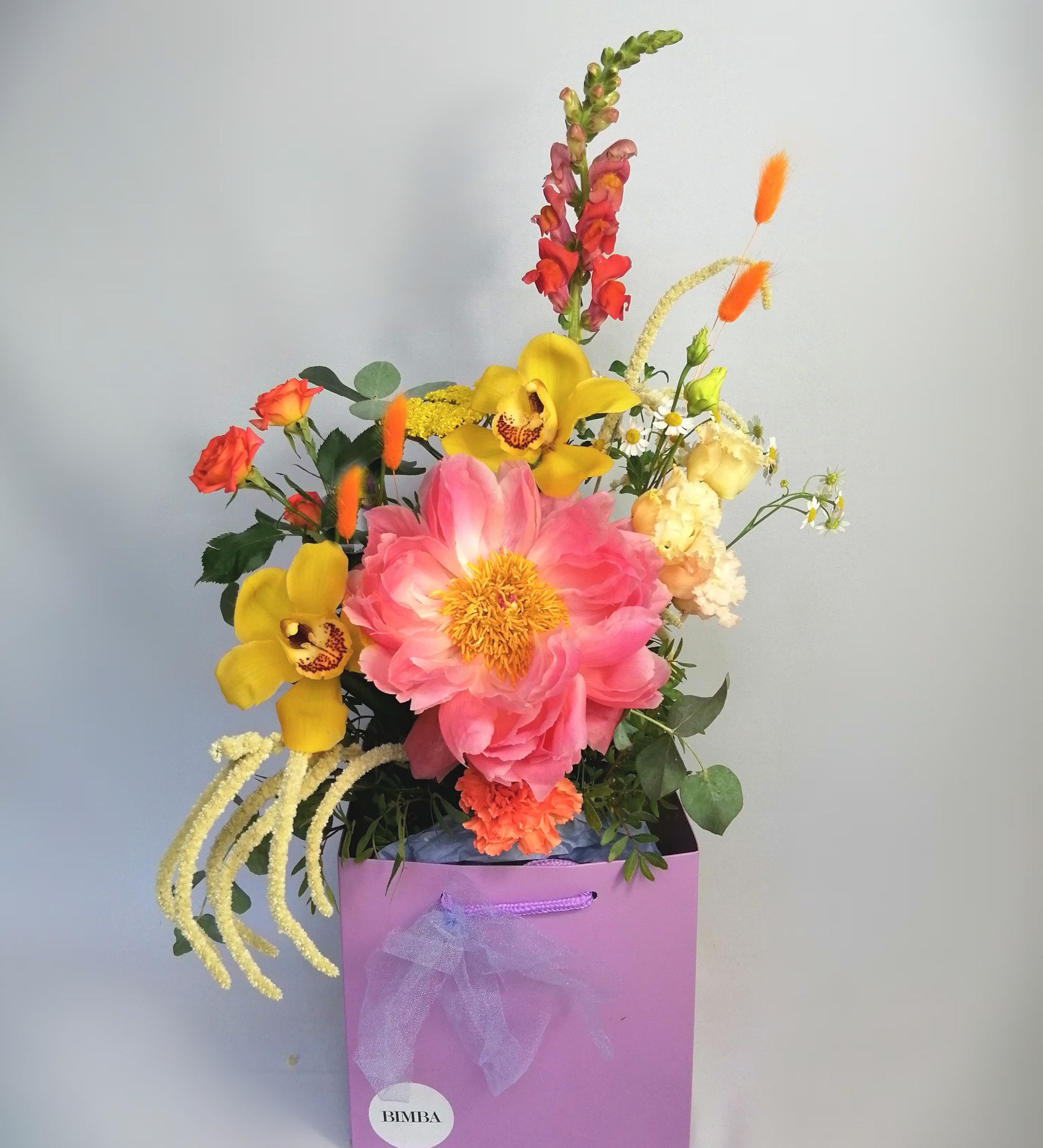 Lovely and happy!  Summery flower arrangement in orange, coral and cream tones, featuring, double lisi, Amaranthus, orange roses, dancer  Caribbean orchids, snapdragon, bunny tails and our star of the season Peony 'coral charm' abundant, nostalgic, large, elegant glossy coral-cream coloured, semi-double flowers with a slight fragrance as they mature. Just beautiful!!  This flower bouquet is available for same day delivery and next day delivery at our floral studio at Highgate ( North London Flowers ).  
