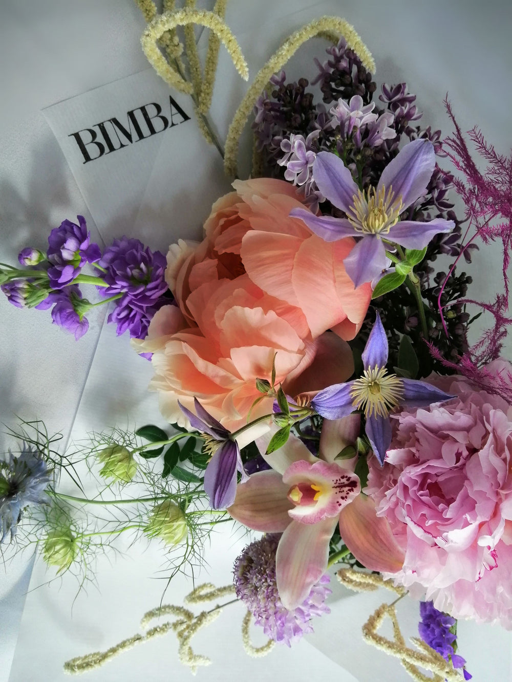 Beautiful flower arrangement, inspired by the breathtaking amalfi coast and the wonderful sunsets.  Featuring a mix of summery flowers in lovely violet, blue and coral tones like caribbean soft pink orchids, sweet scented stock, french clematis, playful bunny tails, scabiosa, Amaranthus, cerise asparagus and our star 'Peony Coral Charm' and 'Peony Angel Cheeks'.