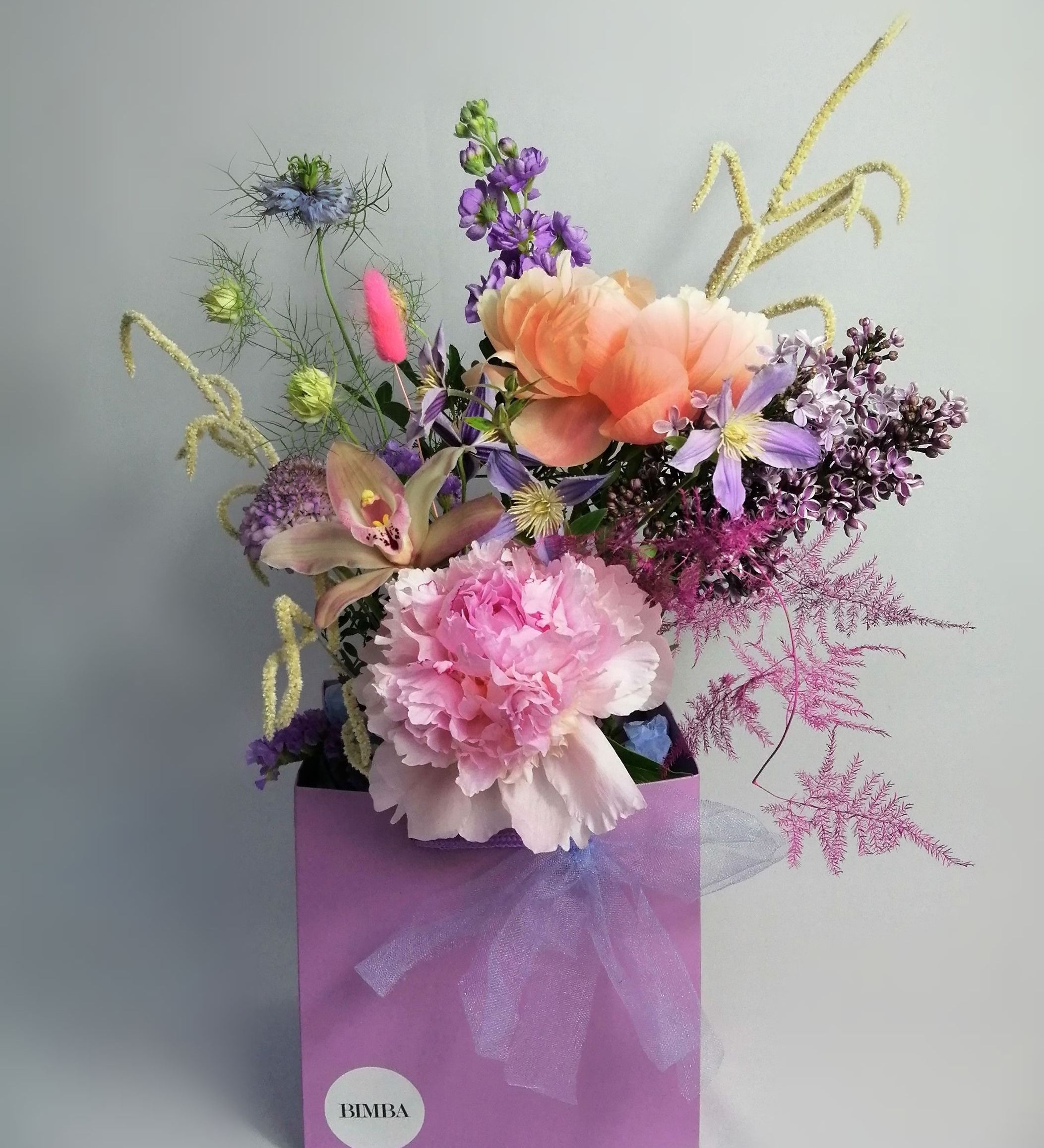 Beautiful flower arrangement, inspired by the breathtaking amalfi coast and the wonderful sunsets.  Featuring a mix of summery flowers in lovely violet, blue and coral tones like caribbean soft pink orchids, sweet scented stock, french clematis, playful bunny tails, scabiosa, Amaranthus, cerise asparagus and our star 'Peony Coral Charm' and 'Peony Angel Cheeks'.