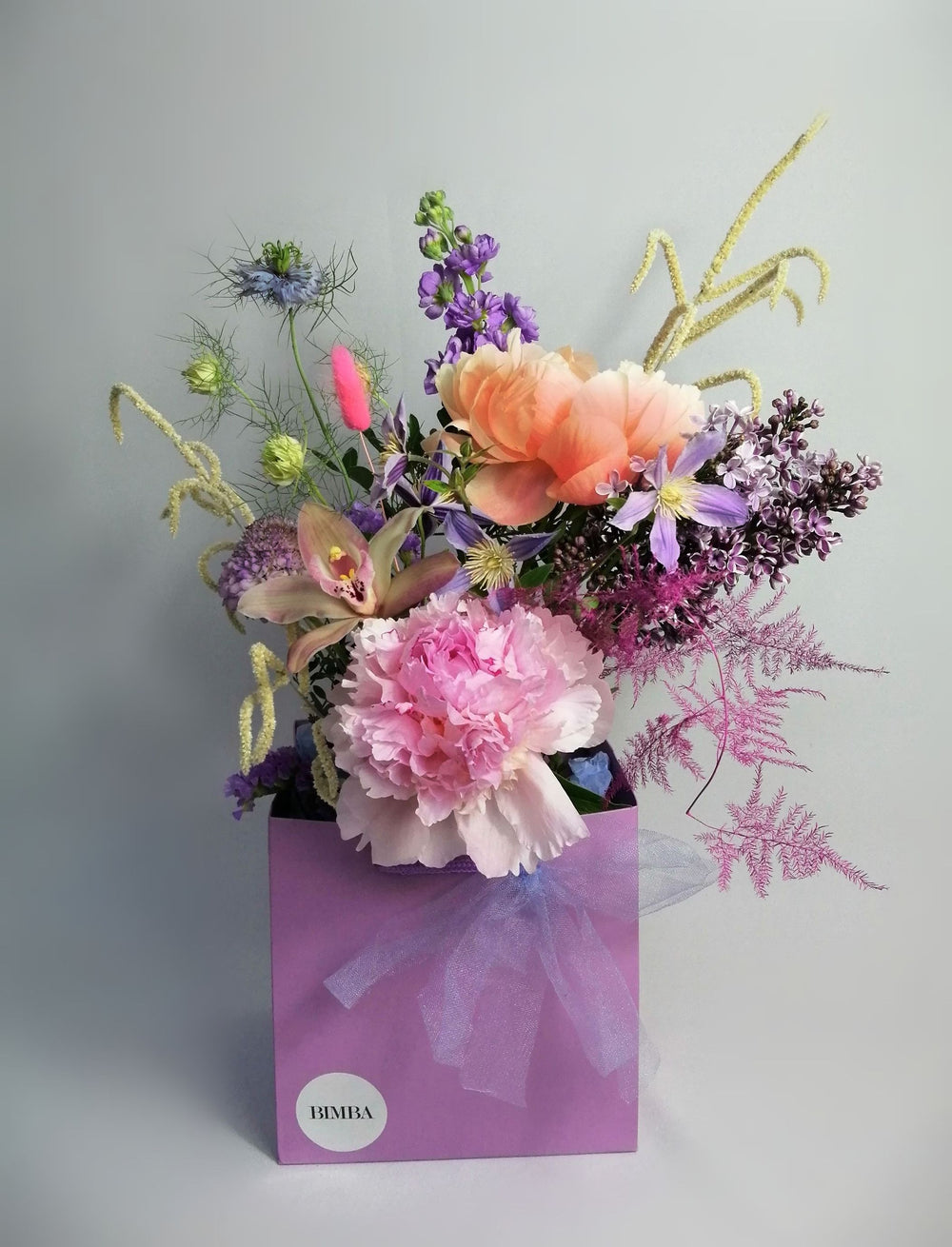 Beautiful flower arrangement, inspired by the breathtaking amalfi coast and the wonderful sunsets.  Featuring a mix of summery flowers in lovely violet, blue and coral tones like caribbean soft pink orchids, sweet scented stock, french clematis, playful bunny tails, scabiosa, Amaranthus, cerise asparagus and our star 'Peony Coral Charm' and 'Peony Angel Cheeks'.