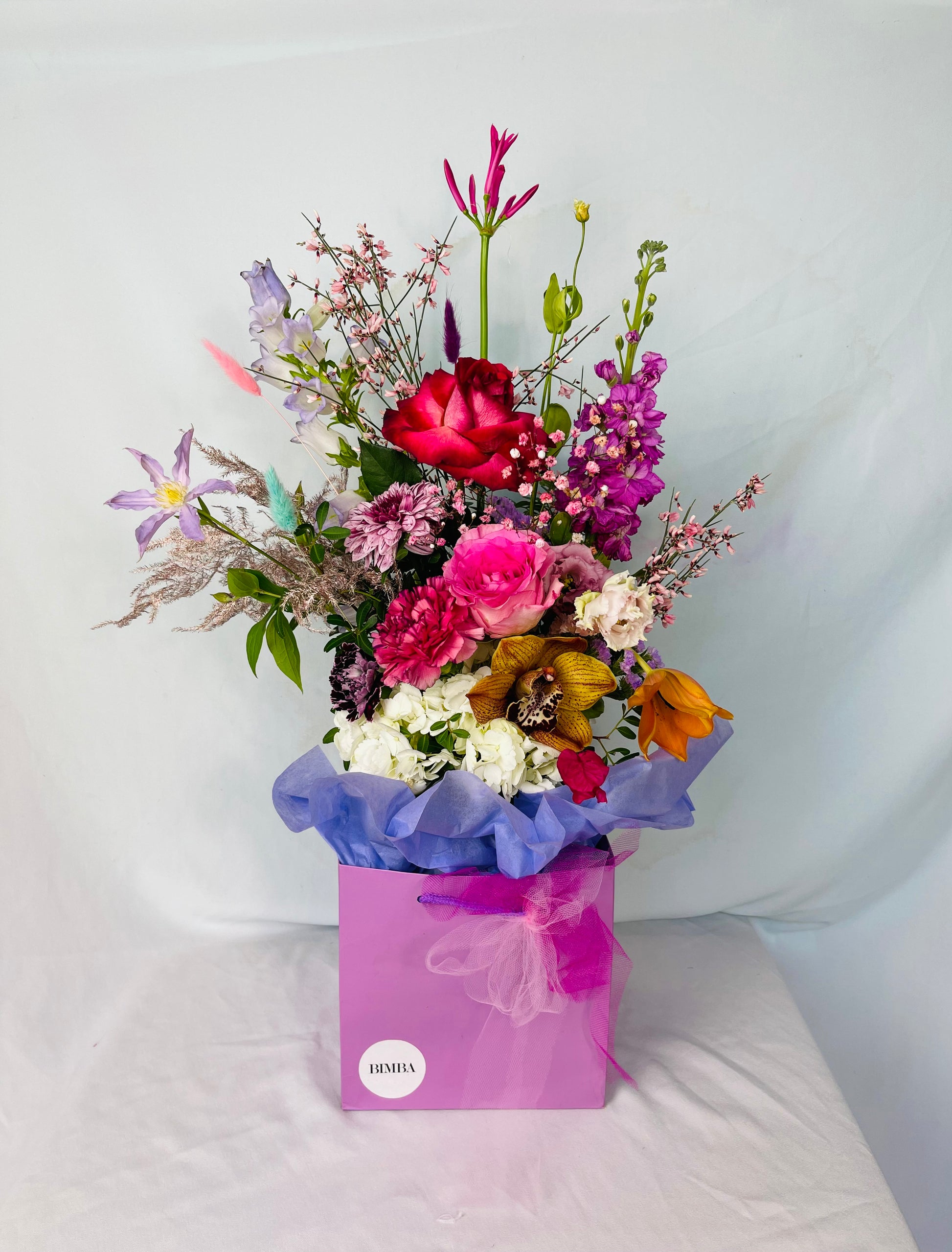 Dancing in the Moon Bouquet is a ovely flower arrangement featuring sweet scented roses, French clematis , double bloom lisianthus, rainbow Gypsophila, luxury cymbidium orchids, sweet scented delphinium, playful bunny tails, champagne asparagus fern and sweet scented eucalyptus. By Bimba Floral Studio.