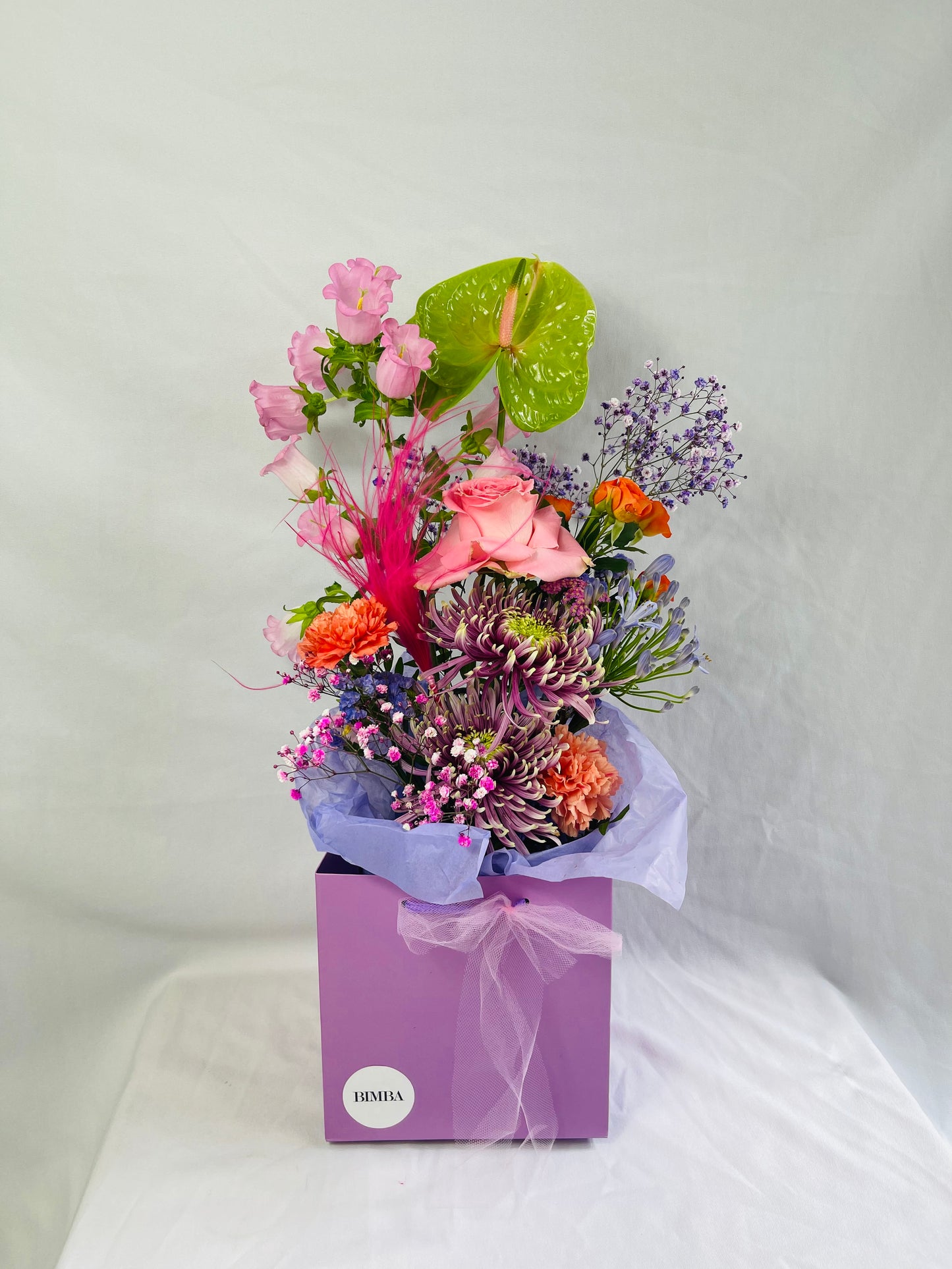 Coolleen bouquet. Stunning flower arrangement featuring caribbean anthurium, lovely achillea, statice in different tones, sweet scented rose, strawberry campanula, chrysanthemum, asclepia, rainbow gypsophila, orange carnations, agapanthus, and hot pink stypha grass. by bimba Floral Studio.